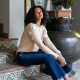 Women's travel-friendly beige and ivory camellia embroidered cashmere sweater with long sleeves.