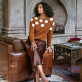 Women's travel-friendly cinder brown cashmere knit sweater featuring white camellia flower embroidery and a matching satin skirt.