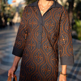 Navy and burnt orange patterned chambray dress with a button front and 3/4 sleeves.