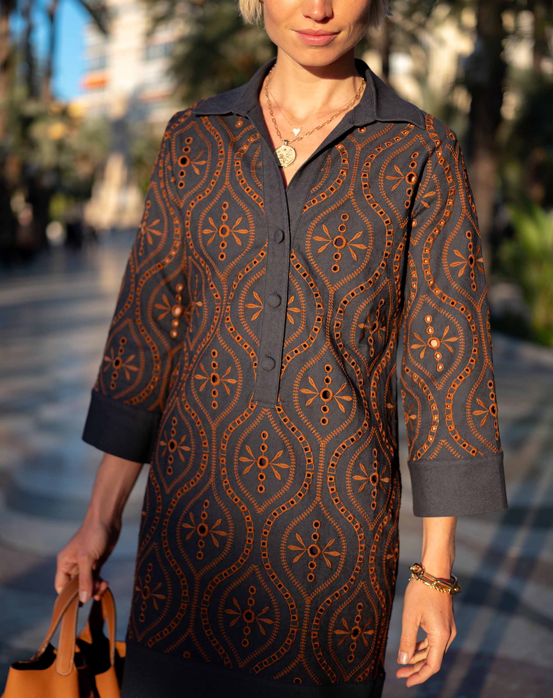 Navy and burnt orange patterned chambray dress with a button front and 3/4 sleeves.