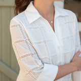 White lace blouse worn by a person with a blurred background