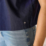 Navy shirt, blue jeans, and bracelets on a neutral background