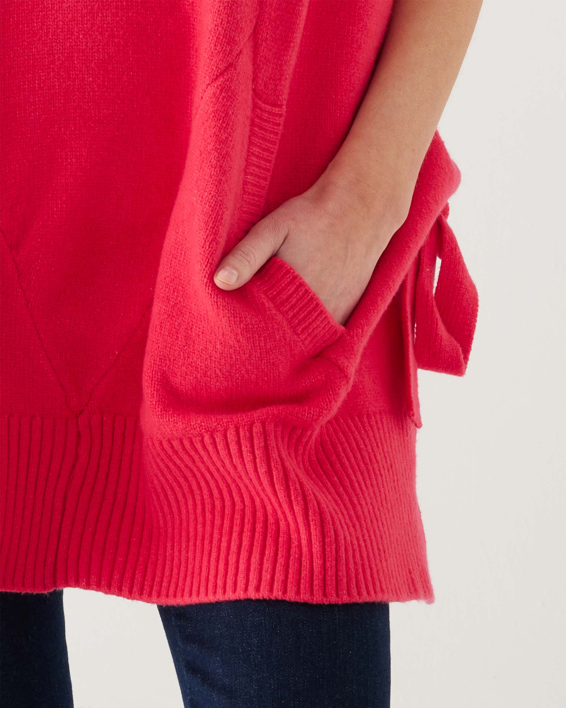 closeup of pocket on woman wearing mersea cape poncho sweater in hibiscus red
