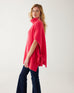 profile of woman wearing mersea cape poncho sweater in hibiscus red