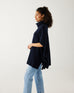 profile of woman wearing mersea cape poncho sweater in navy blue