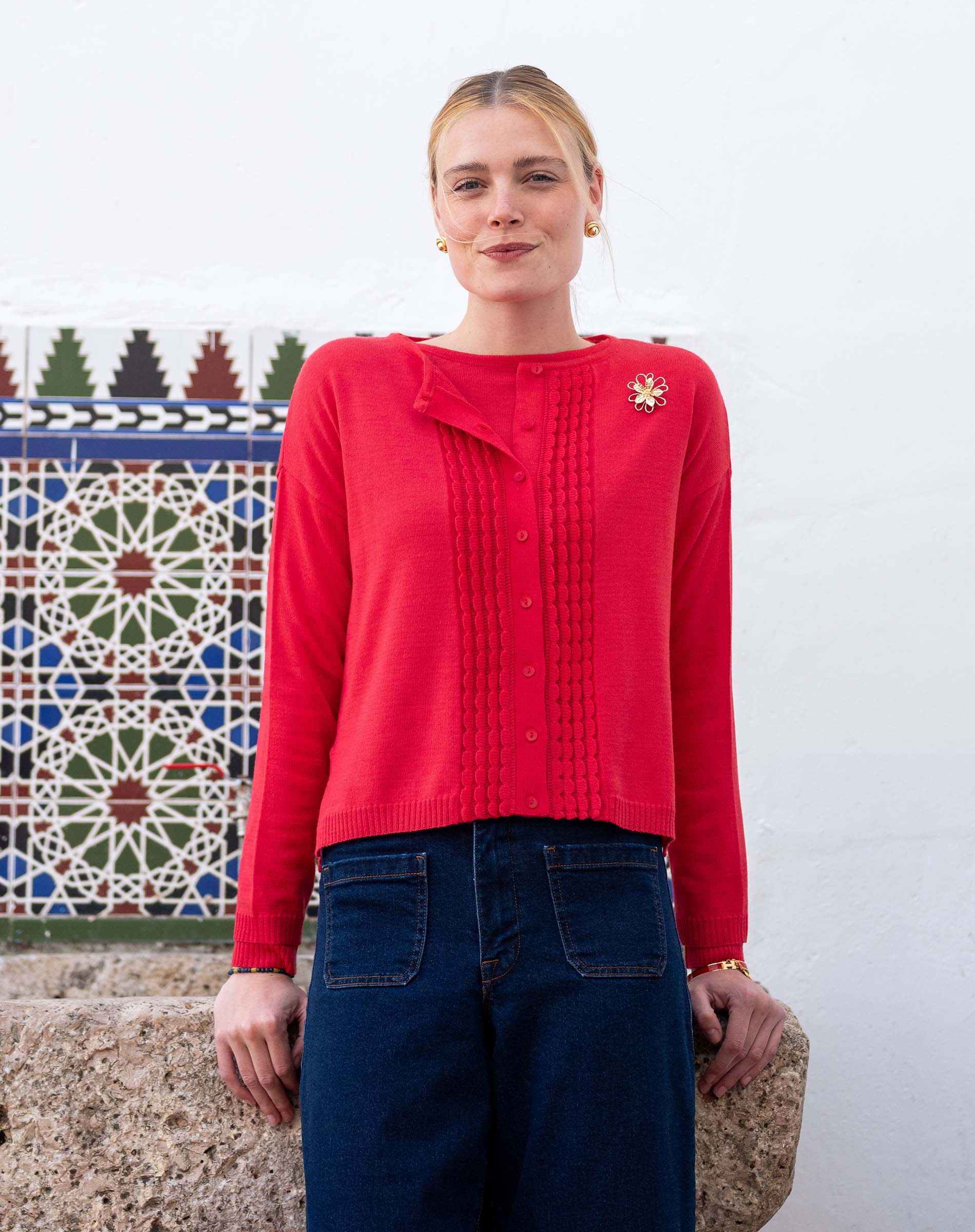 Chili red ruffled cardigan knit with ribbed detailing and a decorative brooch.