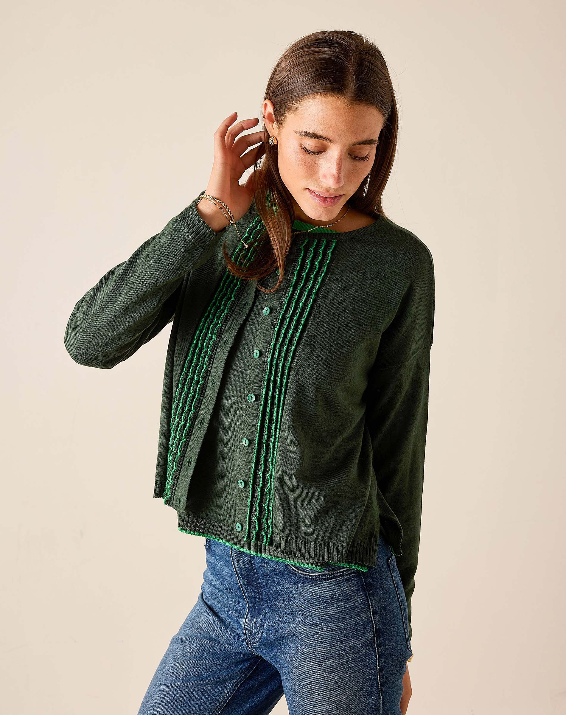 Pine green knit cardigan with vertical ruffle details and button front.