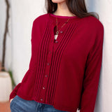 Wine red pleated knit cardigan featuring a buttoned front and textured vertical ribbing.