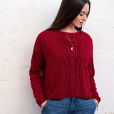 Wine red pleated knit cardigan with button front and ruffled trim.