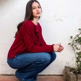 Wine colored ruffle cardigan knit top.