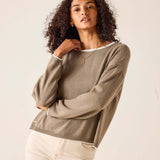 Woman wearing a brown sweater against a plain background