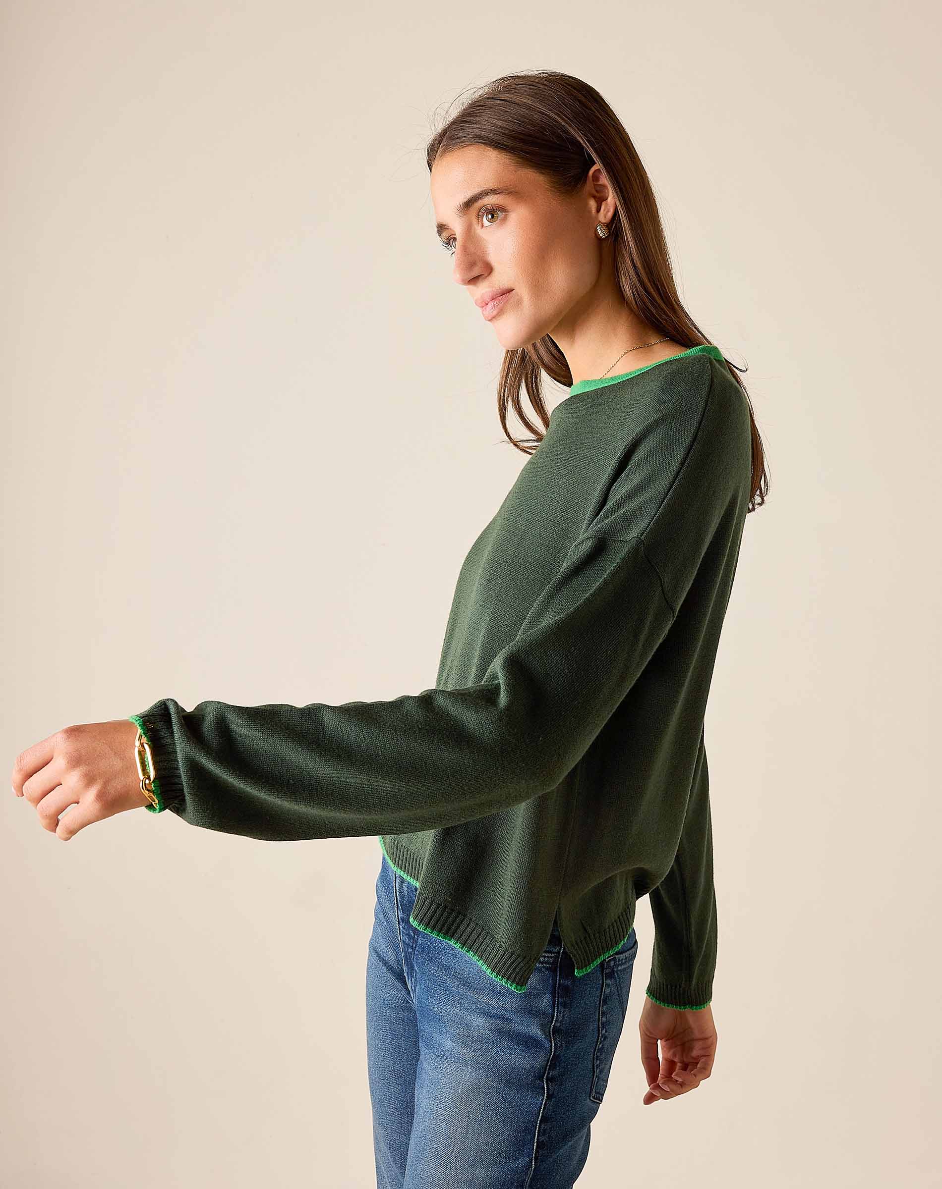 Pine green knit sweater with lime trim on a model.