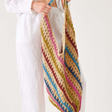 Person holding a colorful striped crochet bag against a white background