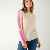 woman wearing mersea carmel cashmere sweater in champagne color with hot pink stripes down sleaves