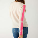 rear view of woman wearing mersea carmel cashmere sweater in champagne color with hot pink stripes down sleaves