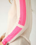 closeup of sleeve on woman wearing mersea carmel cashmere sweater in champagne color with hot pink stripes down sleaves