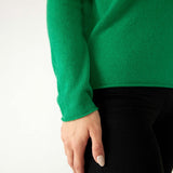 closeup of sleeve on woman wearing mersea carmel sweater in jade