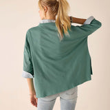Woman wearing a green jacket with a plain background