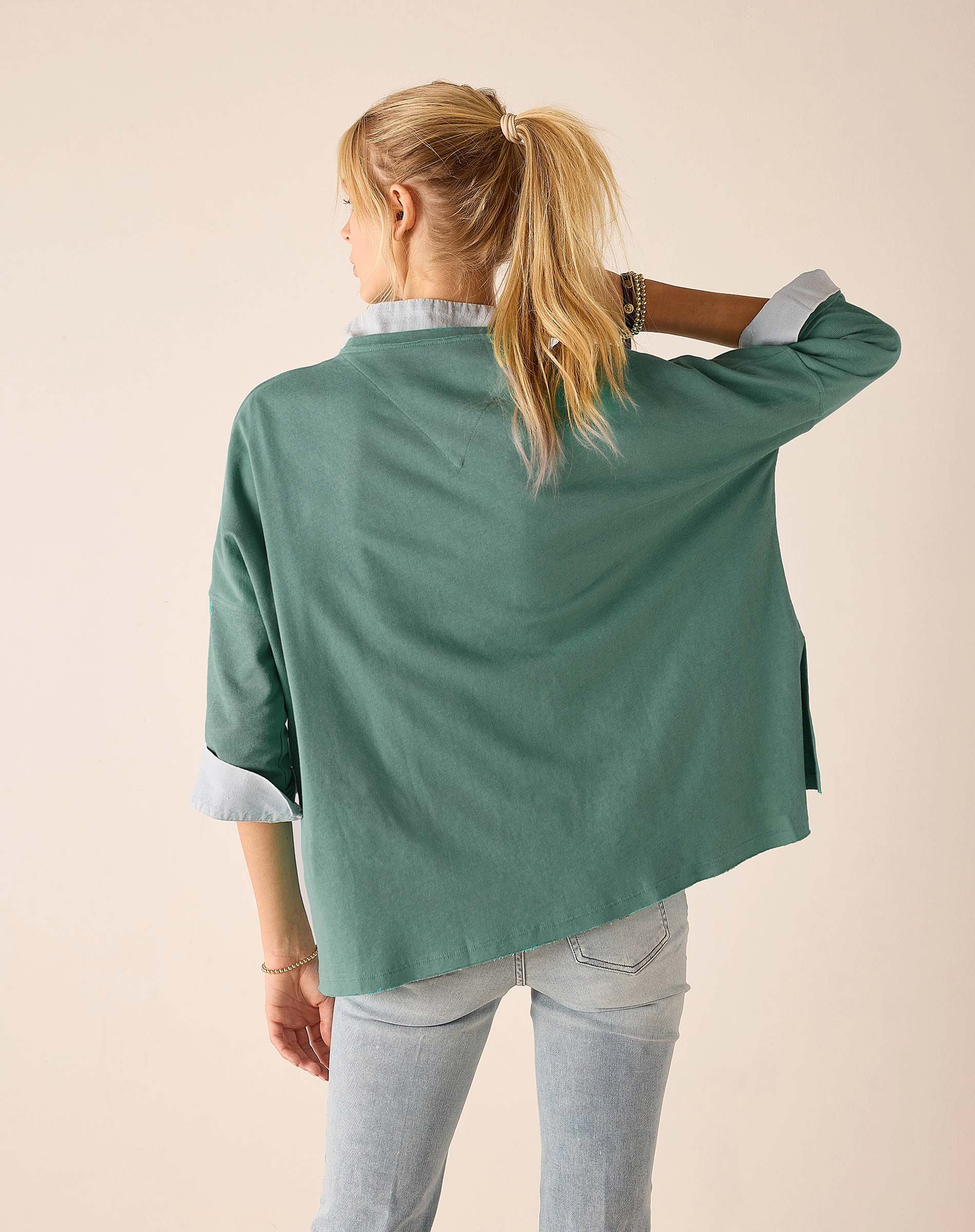 Woman wearing a green jacket with a plain background