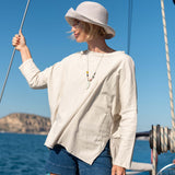 Woman on a boat wearing a white shirt and blue shorts with a scenic background