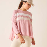 Woman wearing a pink striped shirt and beige cap on a plain background