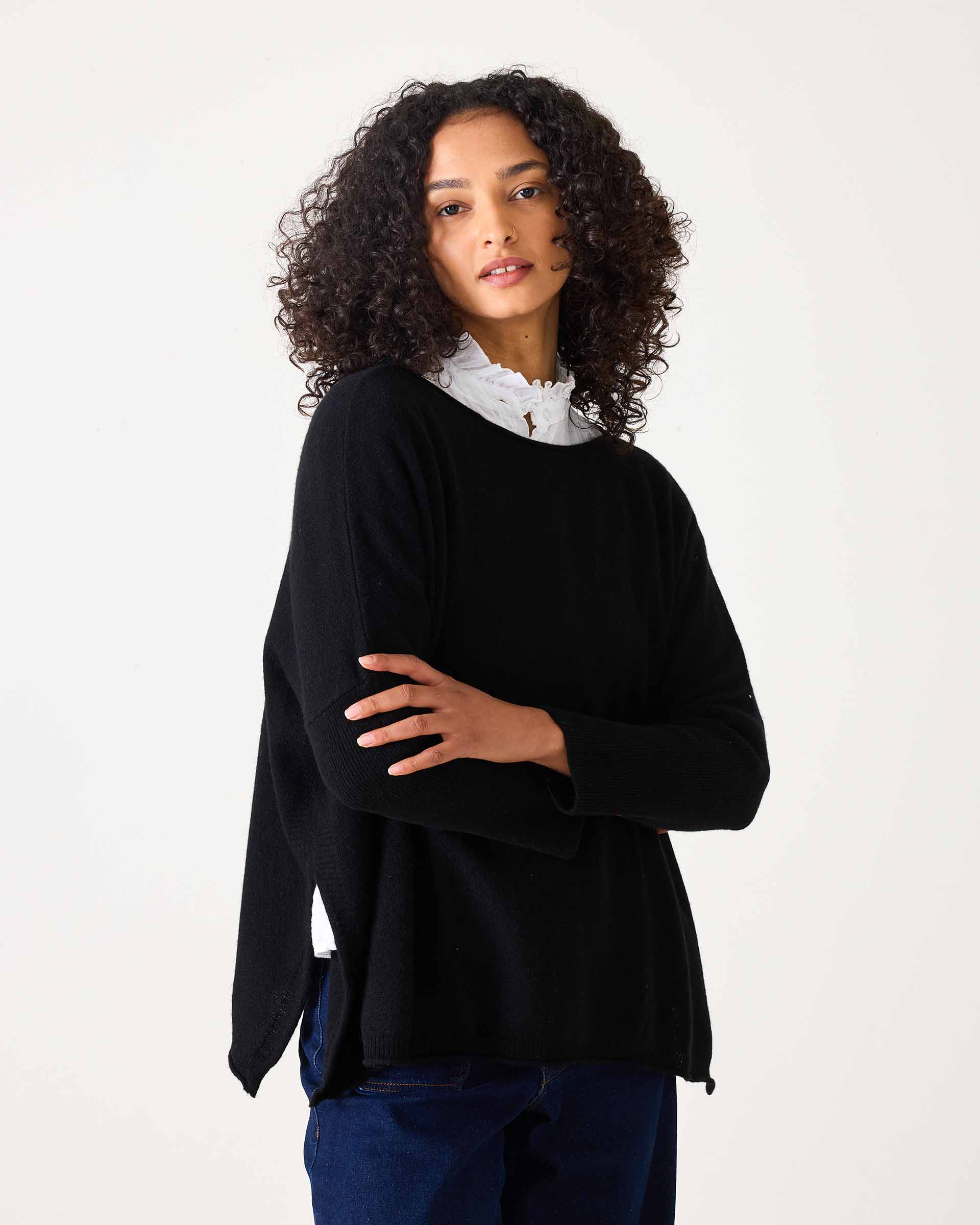 Black cashmere knit sweater with a relaxed fit and draped hem.