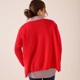 Back view of women's travel-friendly scarlet red oversized cashmere knit wrap layered over a grey striped top.