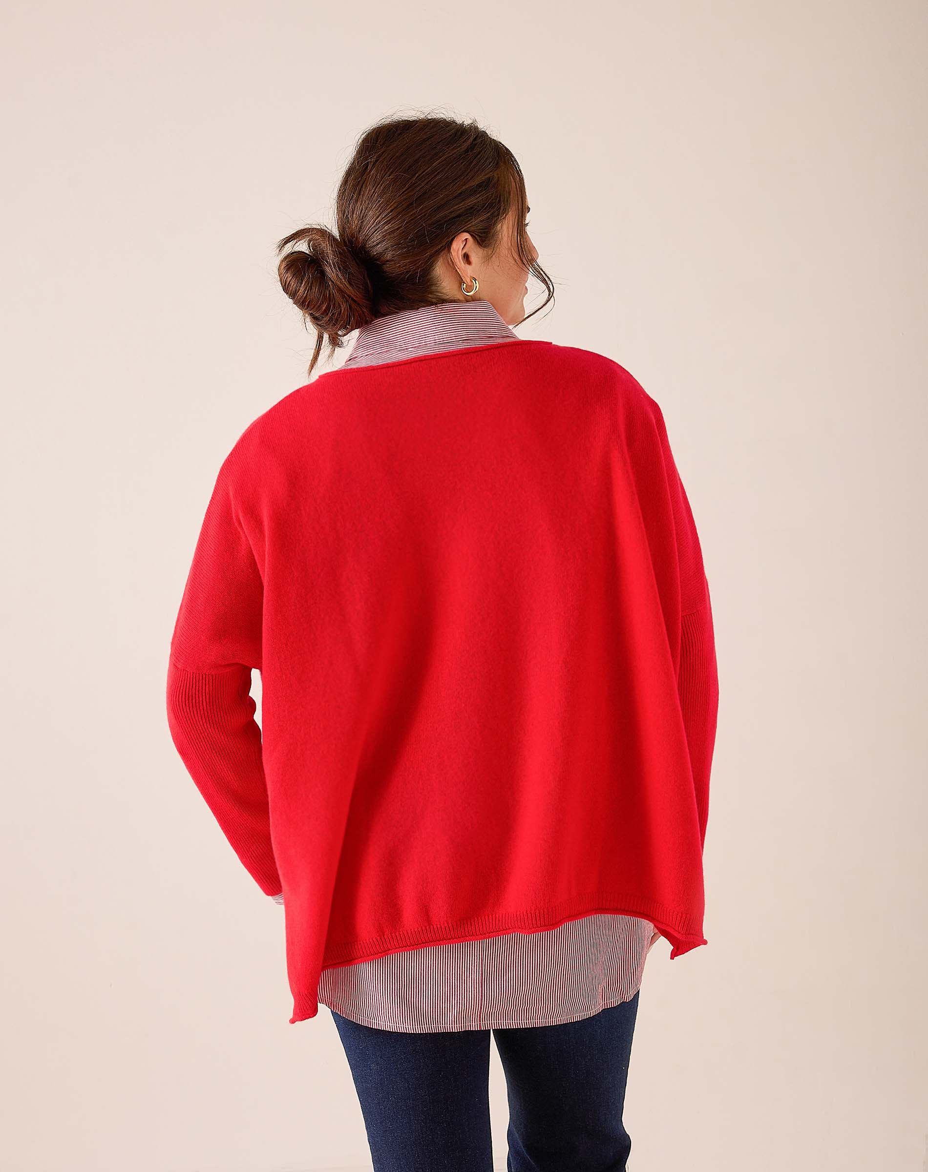 Back view of women's travel-friendly scarlet red oversized cashmere knit wrap layered over a grey striped top.