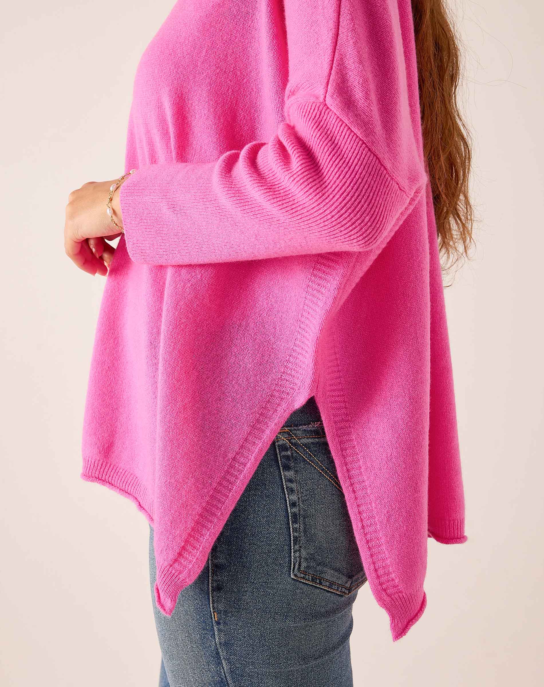Sugar pink oversized knit sweater with ribbed detailing and side slits.