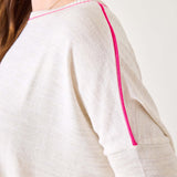 White garment with pink piping on a plain background