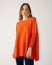 woman wearing mersea catalina contrast sweater in fresh clementine orange  with white trim