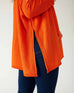 closeup of side split woman wearing mersea catalina contrast sweater in fresh clementine orange with white trim