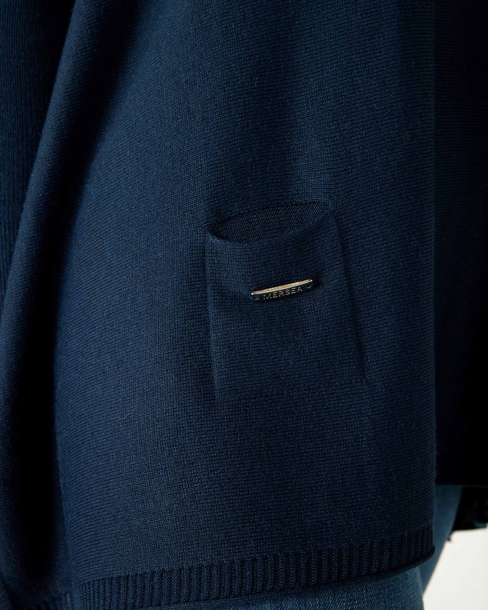 closeup of pocket on woman wearing mersea catalina contrast sweater in navy with chartuese trim