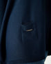 closeup of pocket on woman wearing mersea catalina contrast sweater in navy with chartuese trim