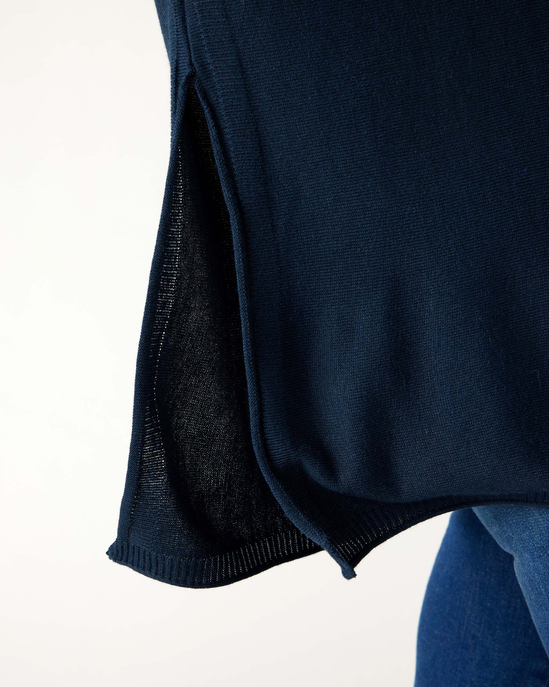 closeup of side split on woman wearing mersea catalina contrast sweater in navy with chartuese trim