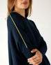 closeup of sleeve on woman wearing mersea catalina contrast sweater in navy with chartuese trim