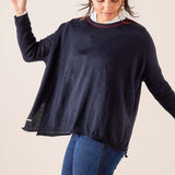Navy blue relaxed fit knit sweater featuring a red and gold contrast trim at the neckline.