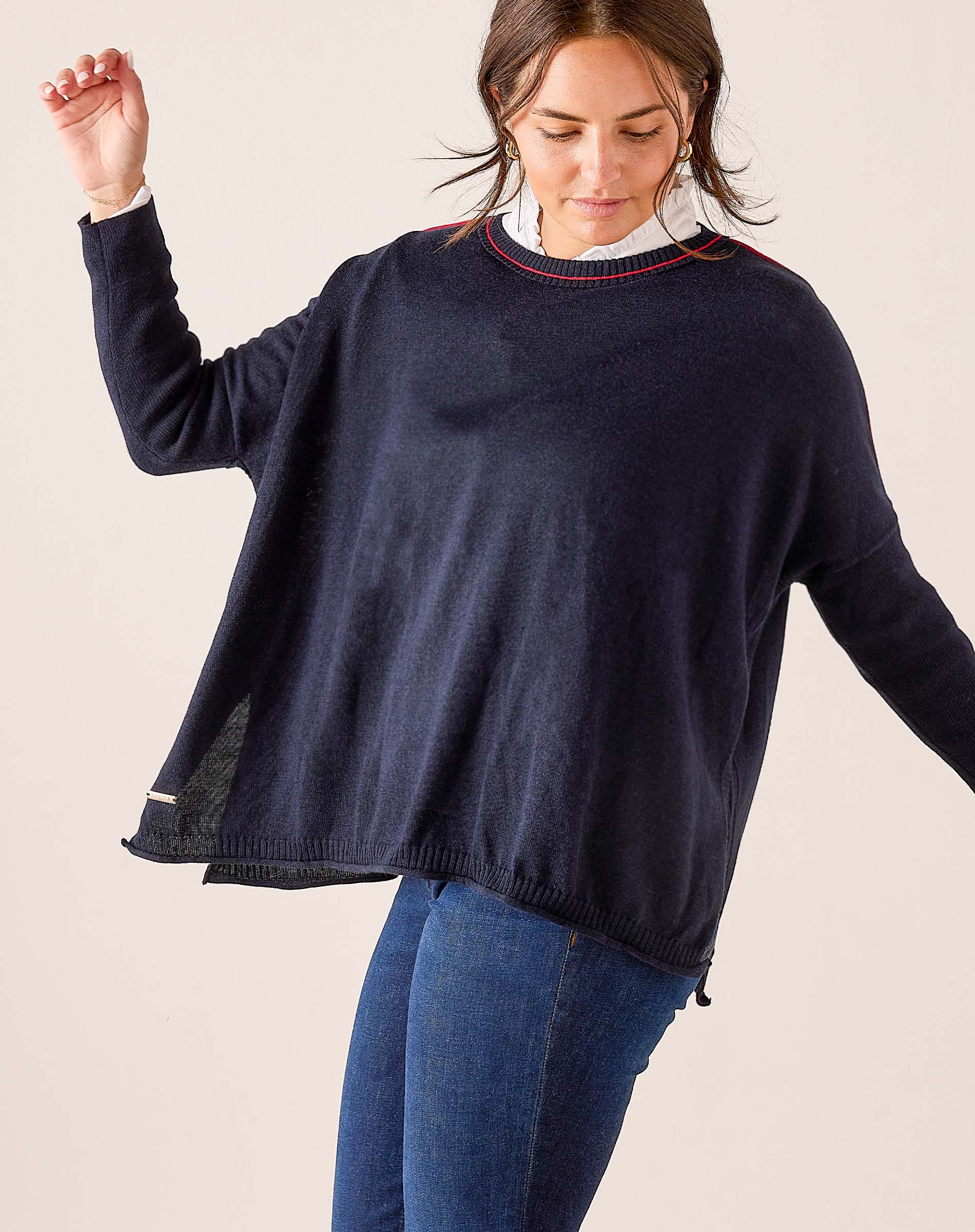 Navy blue relaxed fit knit sweater featuring a red and gold contrast trim at the neckline.