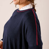 Navy blue knit sweater featuring red contrast trim and a relaxed fit.