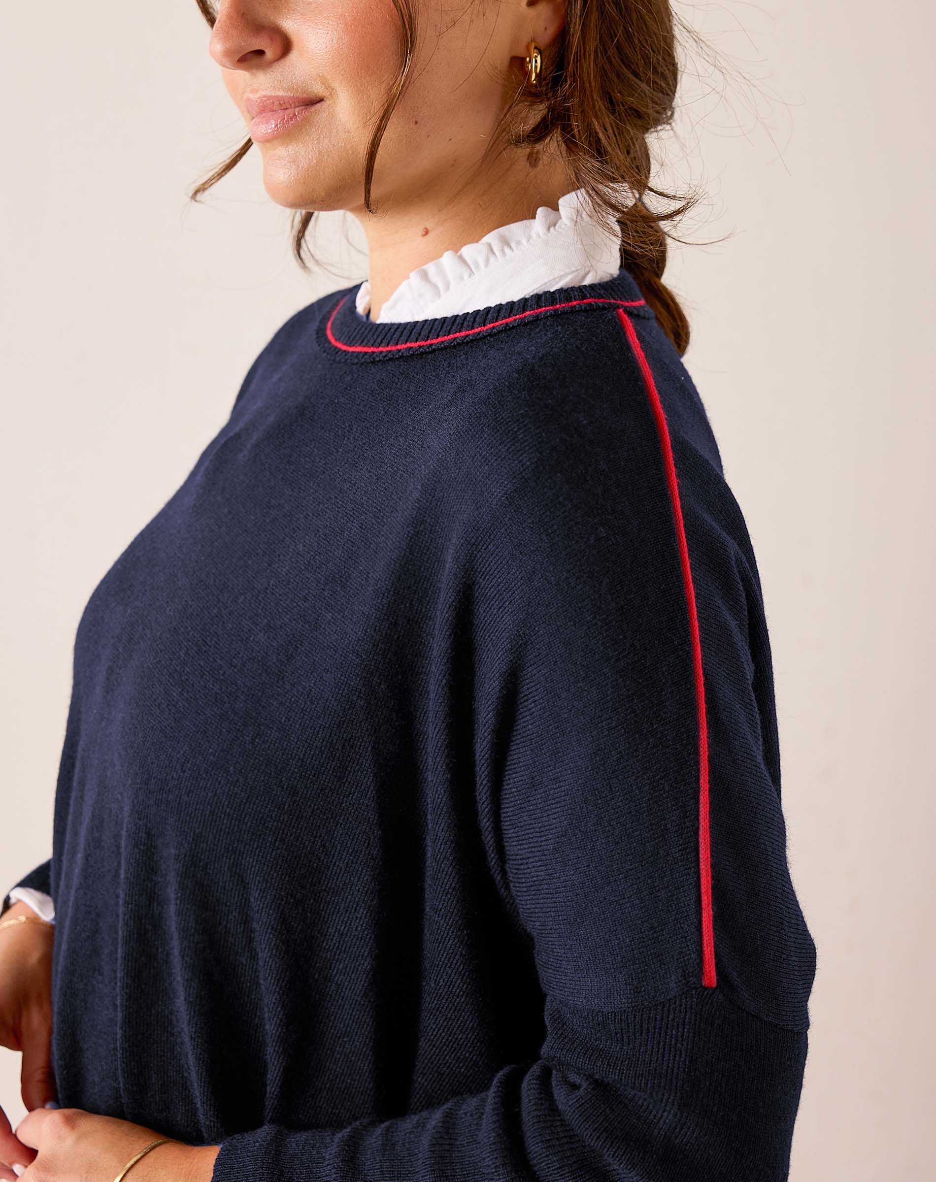 Navy blue knit sweater featuring red contrast trim and a relaxed fit.