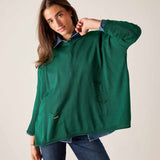 Parakeet green cotton crewneck knit top with front pockets worn over a button-down shirt.