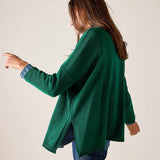 Side view of the parakeet green cotton crewneck knit top over blue jeans.