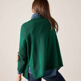 Back view of women's travel-friendly parakeet green cotton crewneck top with a layered shirt and jeans.