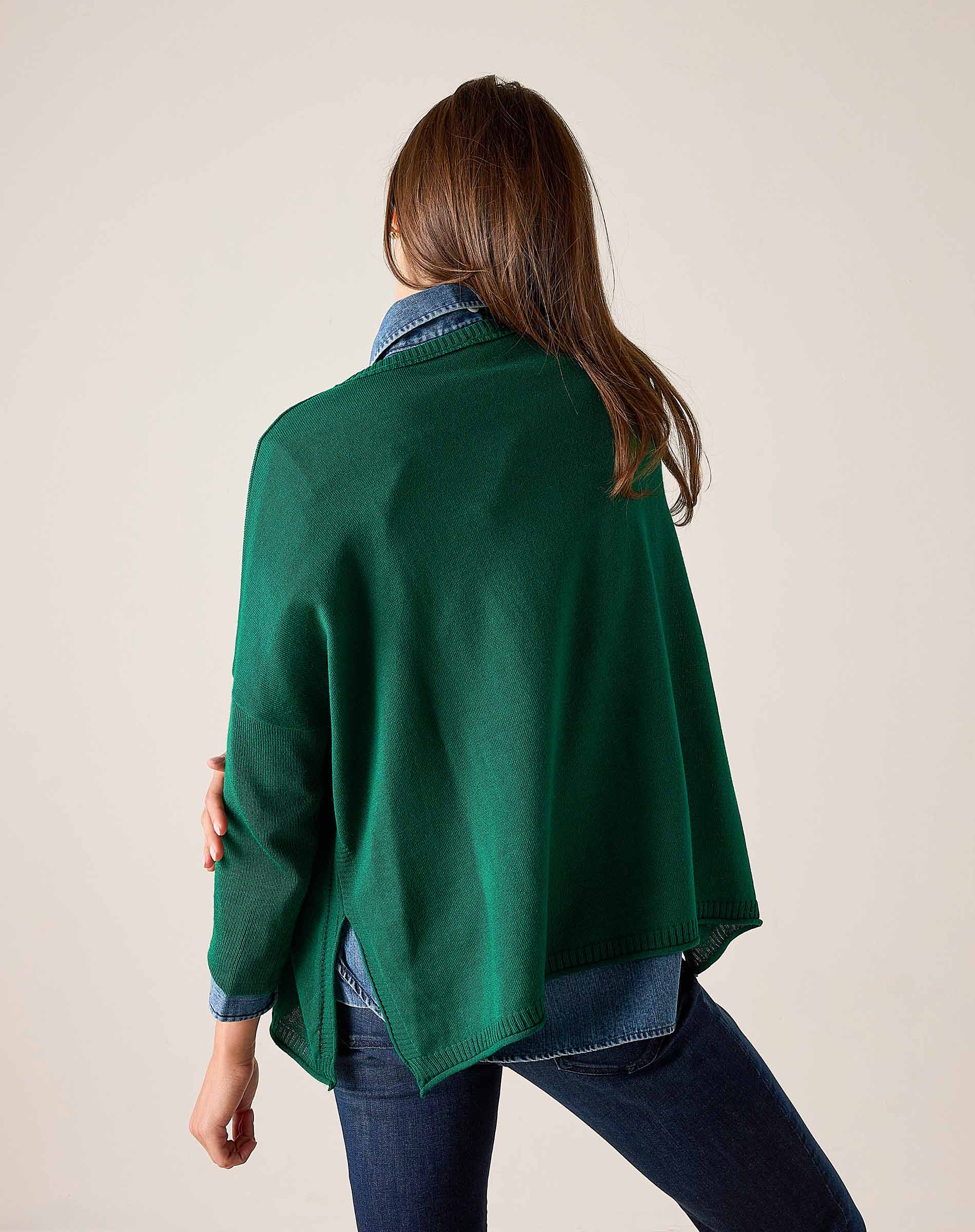 Back view of women's travel-friendly parakeet green cotton crewneck top with a layered shirt and jeans.