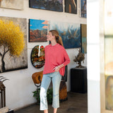 Woman standing in an art gallery surrounded by various paintings.