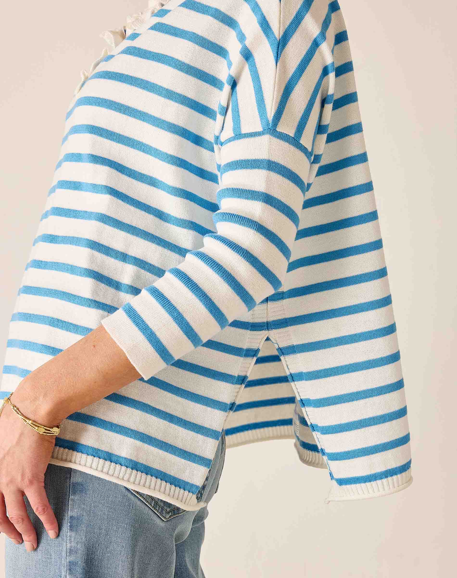 Blue and white striped sweater worn by a person on a plain background