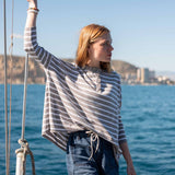 MERSEA women's travel-friendly grey striped ruffled henley top in a beach setting.