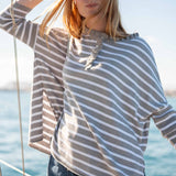 Grey striped cotton ruffle henley top worn on a boat at sea.