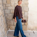 Walnut and marine striped ruffle henley in cotton; paired with wide-leg denim jeans.