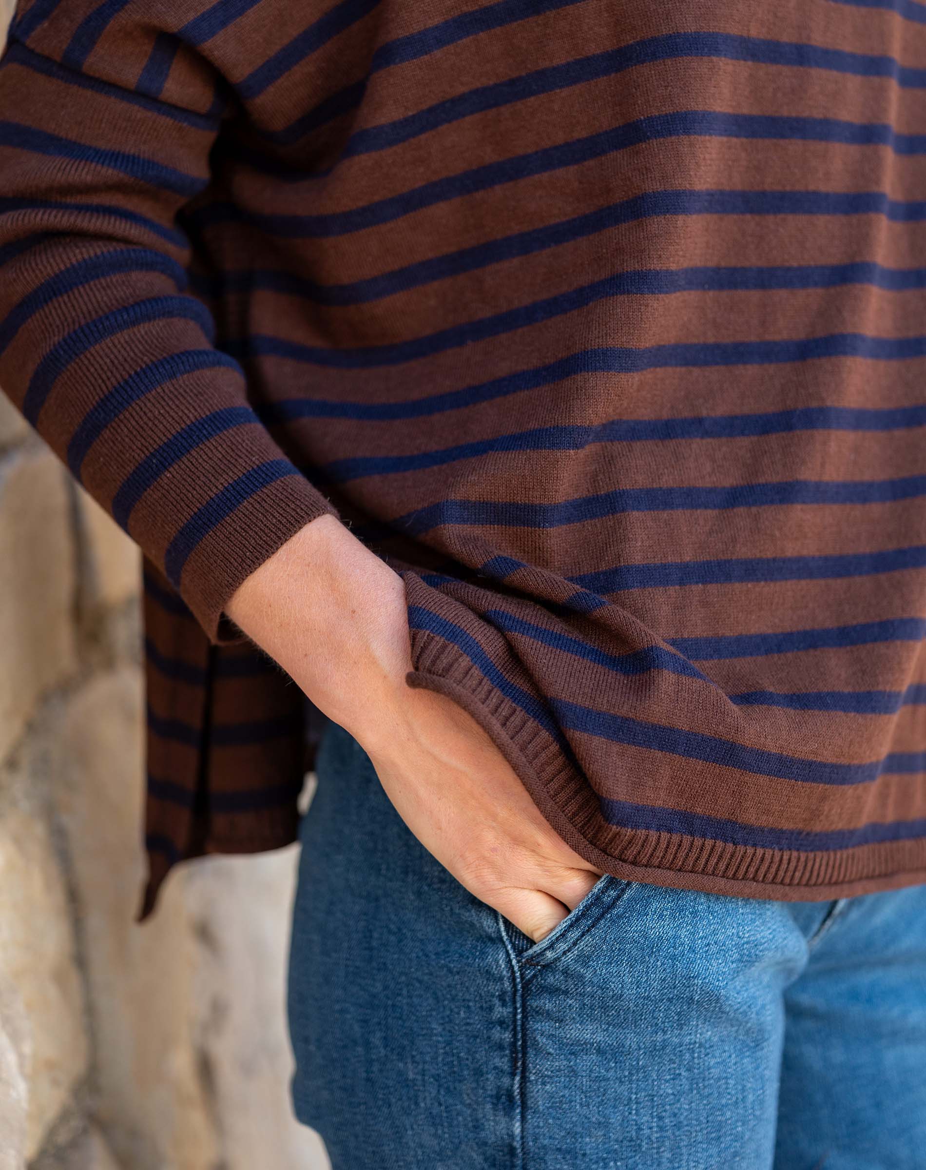 Walnut and marine striped knit Henley top with a ruffle detail.